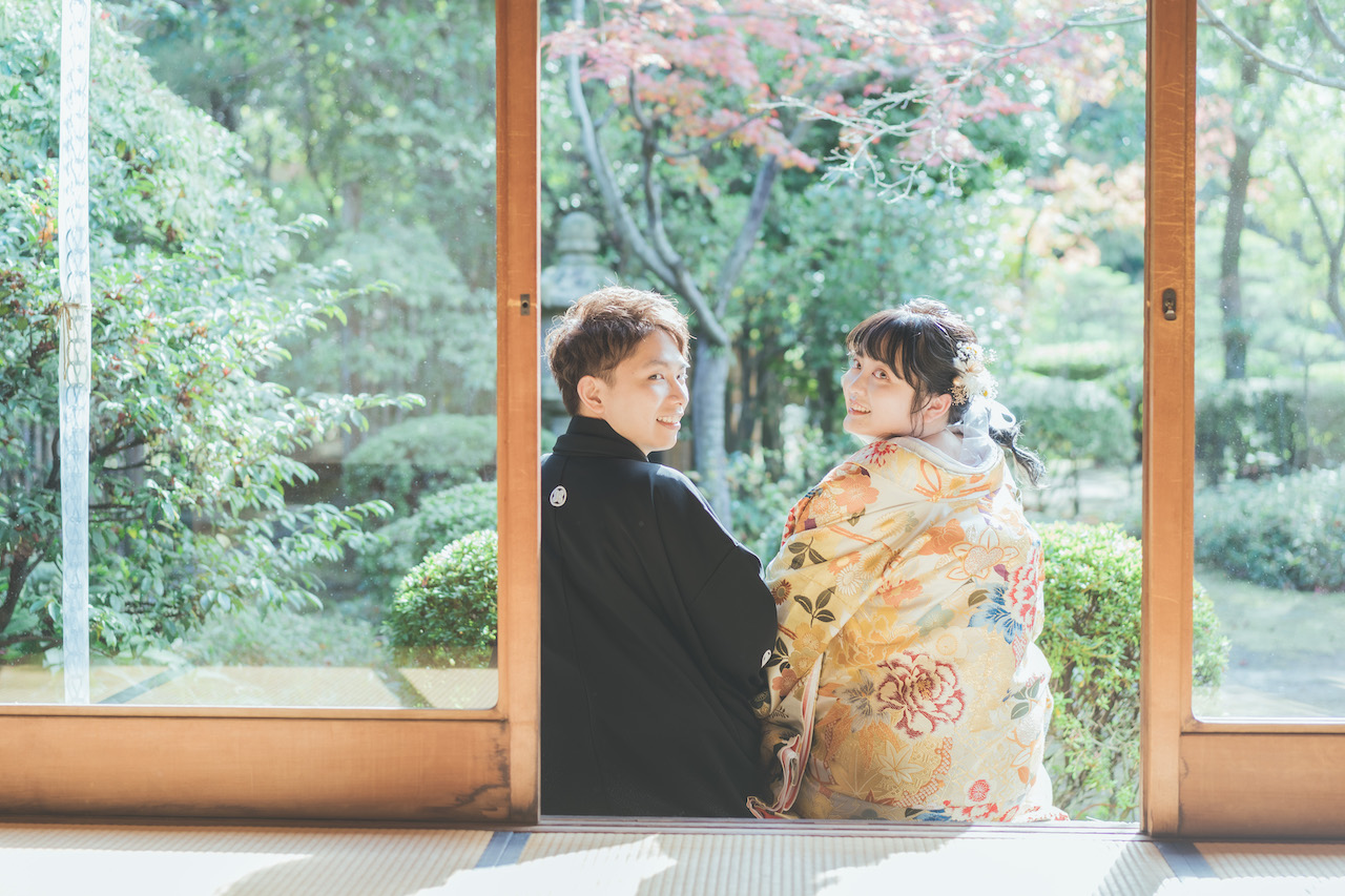 縁側で新郎と新婦が並び、ふたりとも振り向いてこちらを見ている写真