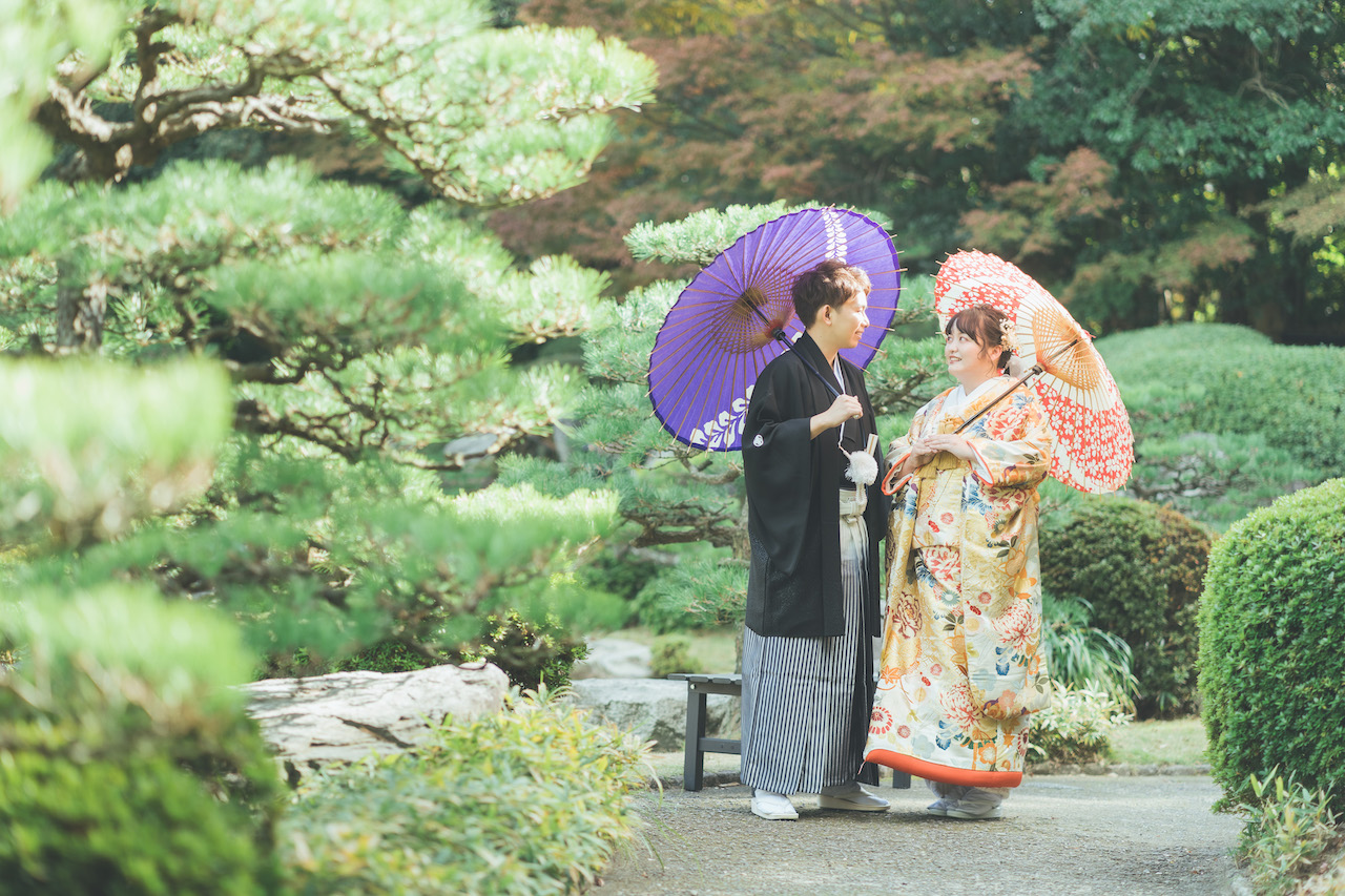新郎と新婦が和傘をさしてお互いを見つめ合っている写真