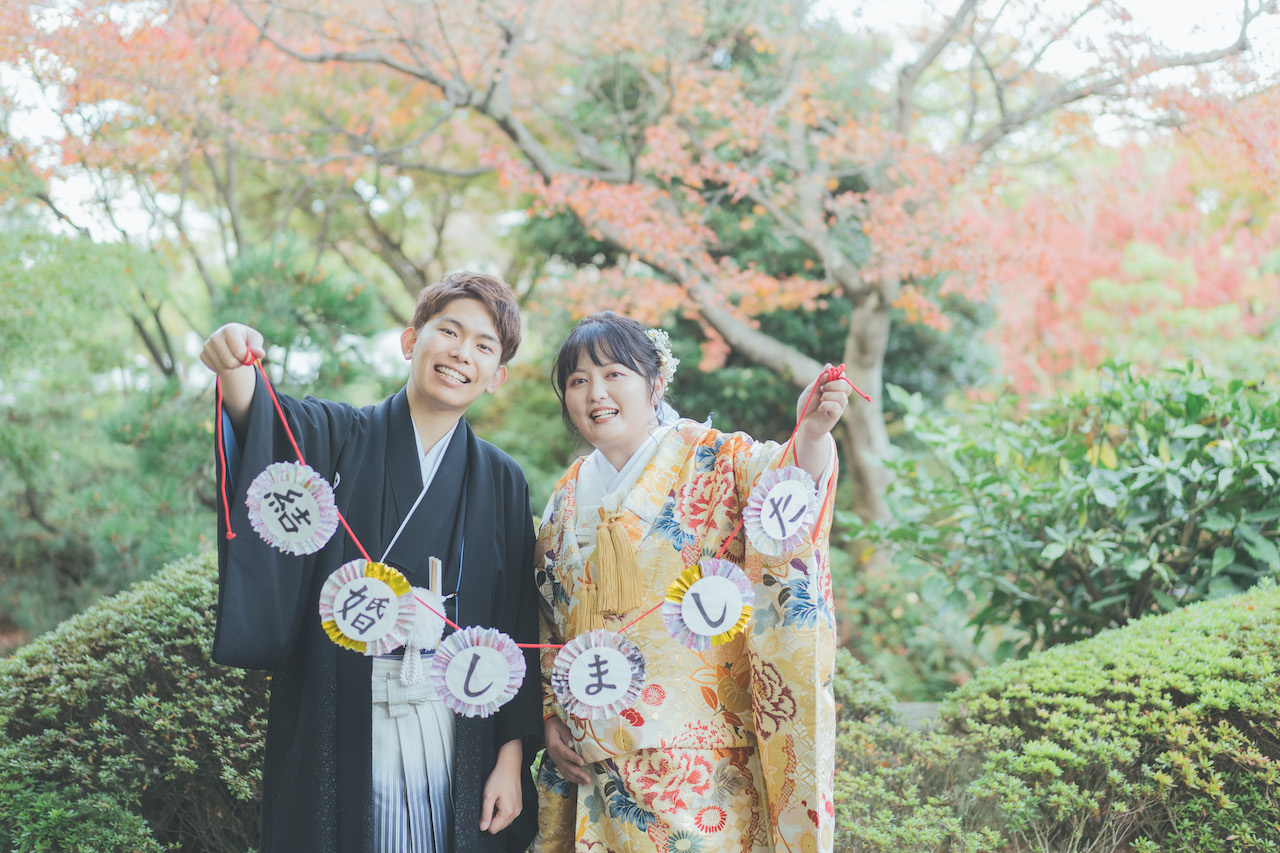 新郎と新婦が 結婚しました と書いてあるガーランドを持っている写真