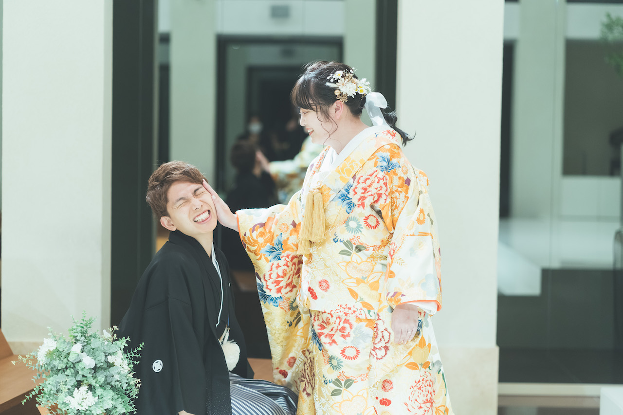 新婦が新郎の頬をペチンと叩き、新郎がいーっとした顔をしている写真