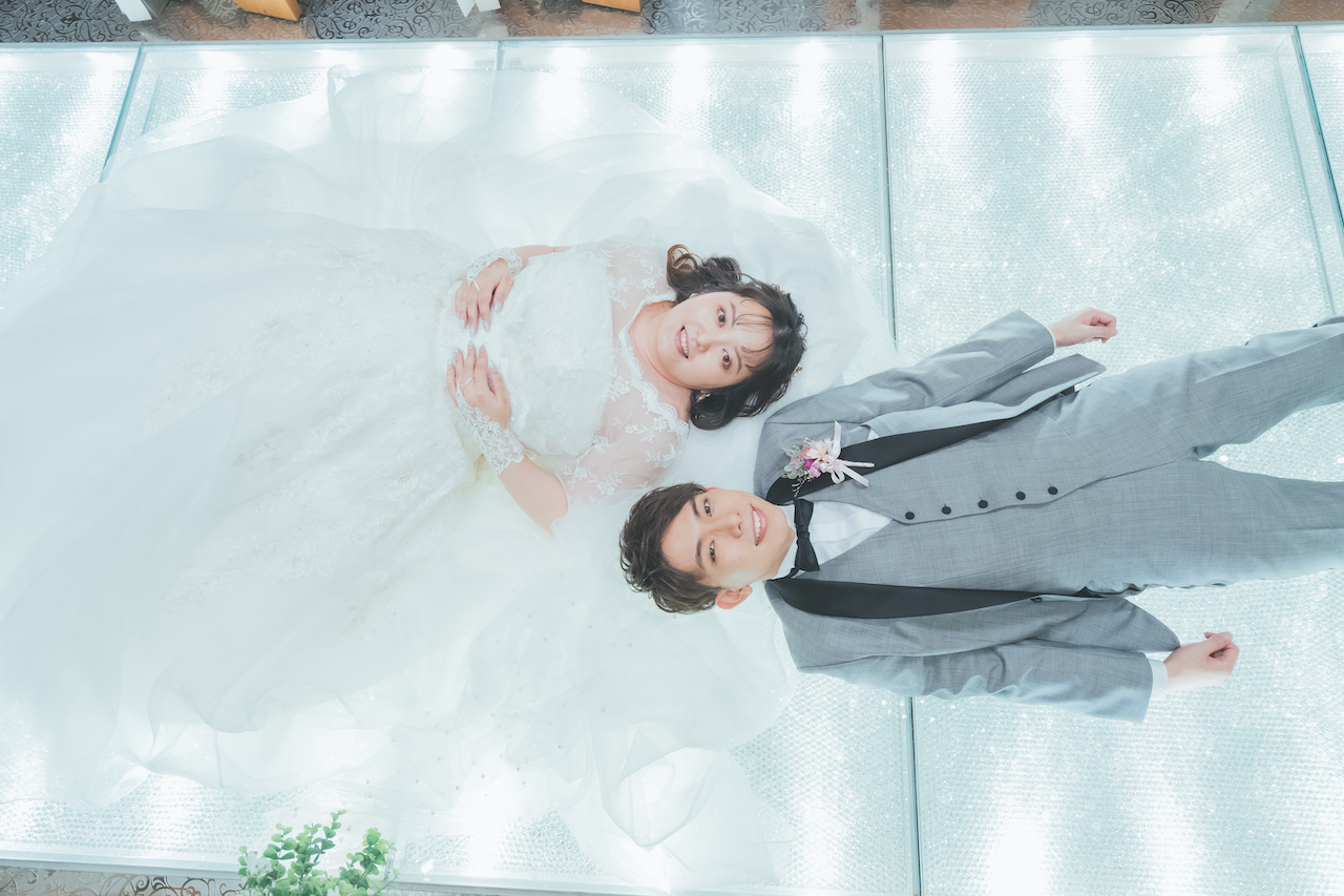 新郎と新婦がチャペルで寝転がって上を向いている写真
