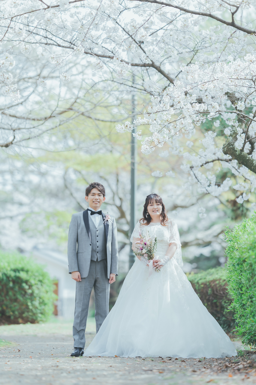 新郎と新婦が桜の下でにこやかにしている写真