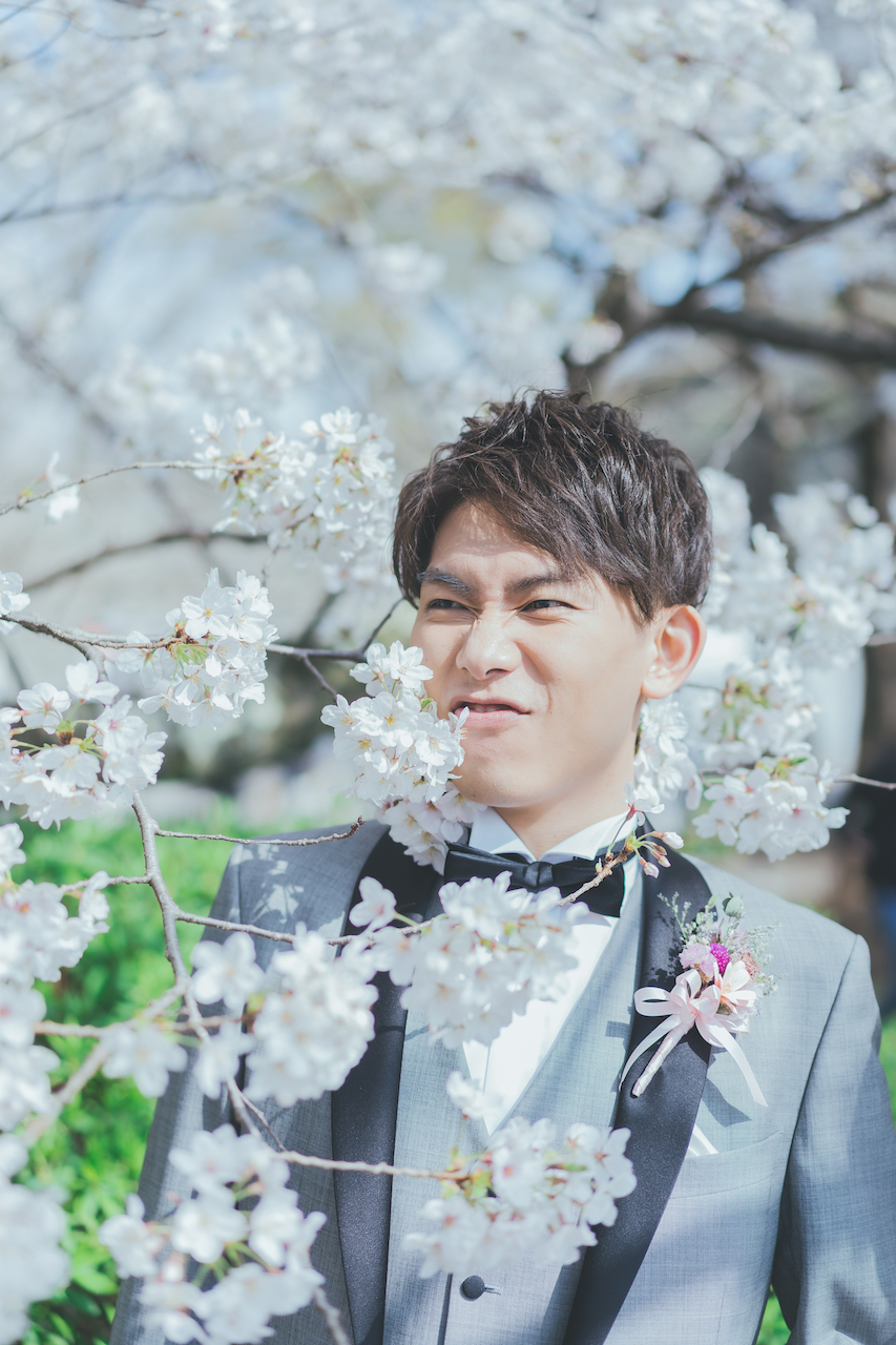 新郎が桜の中ですごい顔をしている写真