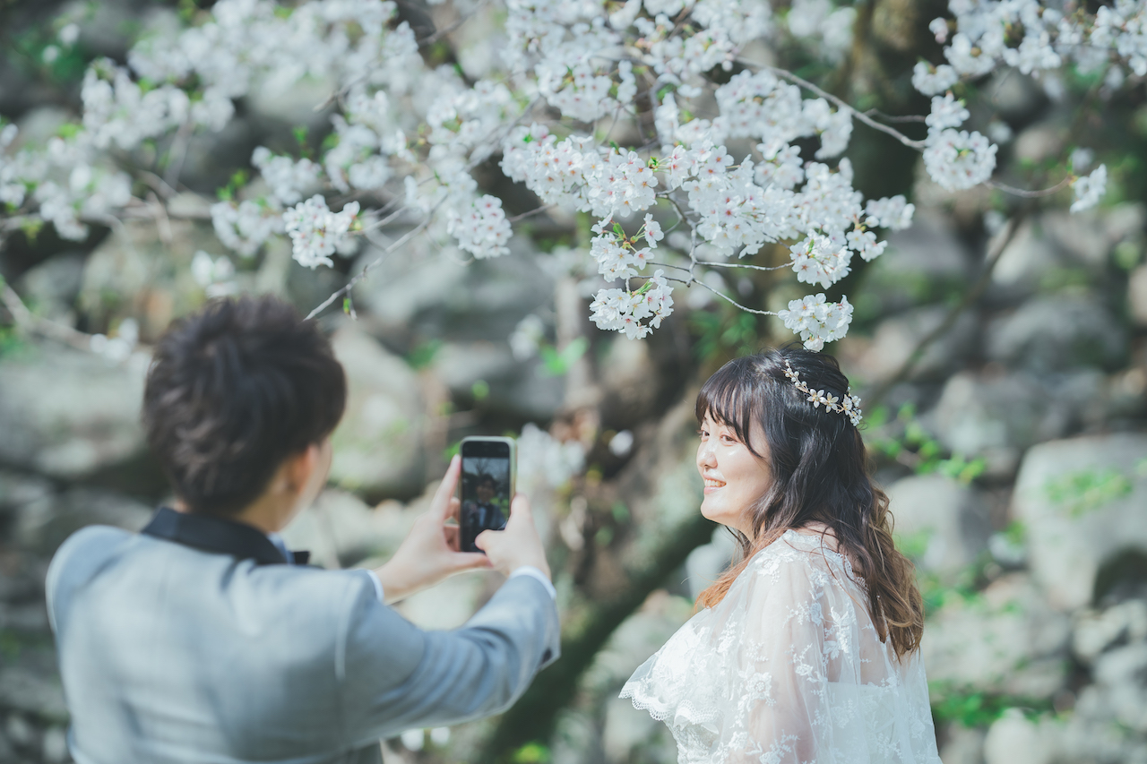 新郎が新婦の写真を取ってあげているような写真