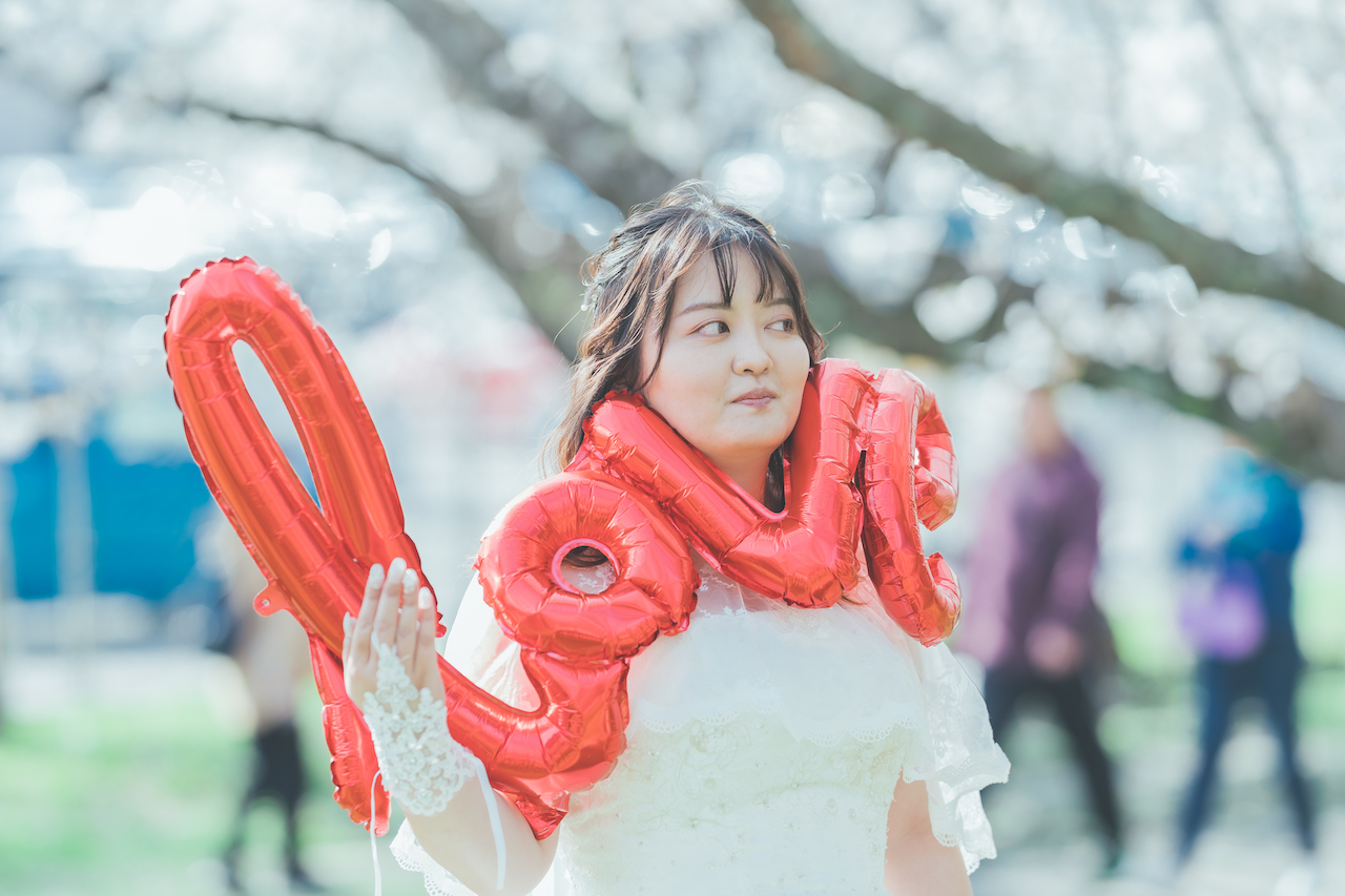 新婦が LOVE と書かれたバルーンを首に巻いている写真